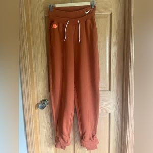 dark orange Nike high-waisted, cuffed sweatpants